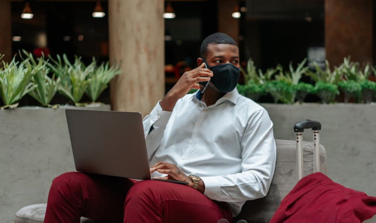 Man Sitting on Sofa While Talking on the Phone