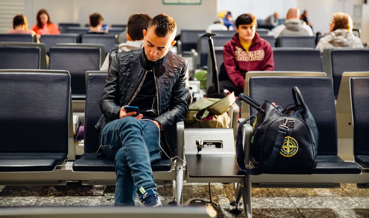 Man in Black Leather Jacket Sitting on Chair