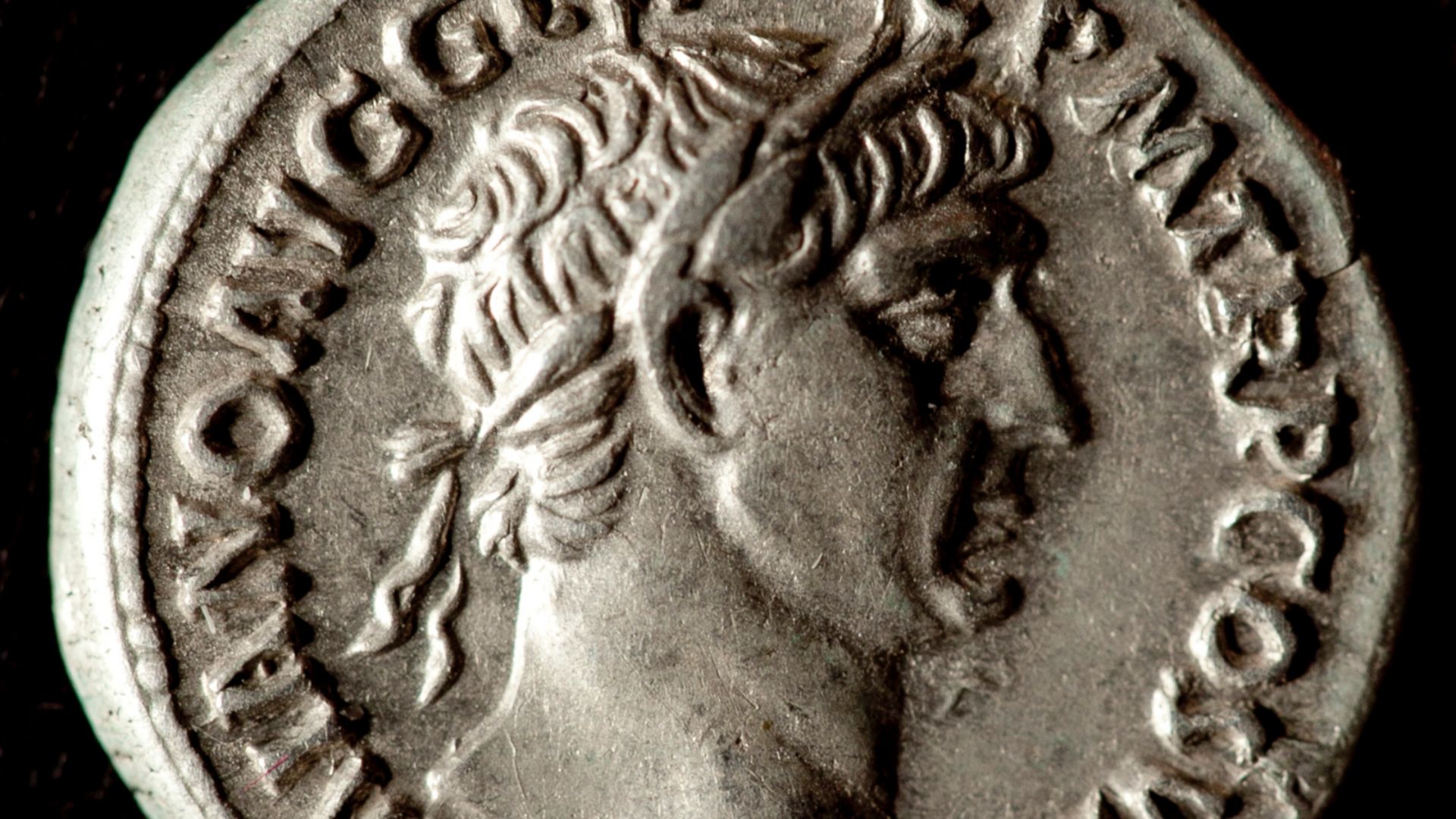 Obv. IMP TRAIANO AVG GER DAC PM TR P COS V PP. Laureate head right; Rev. SPQR OPTIMO PRINCIPI. Dacian wearing peaked cap, seated on shield in mourning, with sword below. Reference: RIC II 219, BMC 175, RSC 529.
The legend on the obverse abbreviates Imperator. Trajan. Augustus. Germanicus. Dacius. Pontifex Maximus. Tribuniciae Potestate. Consul V. Pater Patriae, and the reverse, Senatus Populus Que Romanus. Optimo Principi is not abbreviated but spelled out in full. Trajan was notorious for the length of his numismatic inscriptions, which are the longest of any emperor. Here, the titles actually continue onto the reverse of the coin. They all translate as