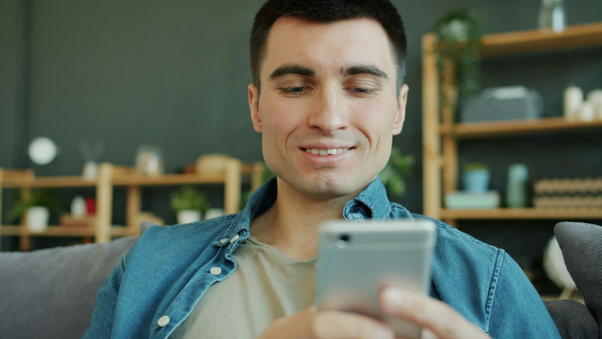 Man smiling while looking at his smartphone