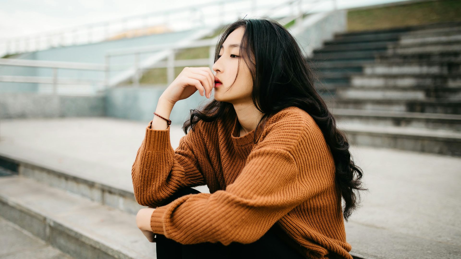 woman wearing brown sweater holding lips