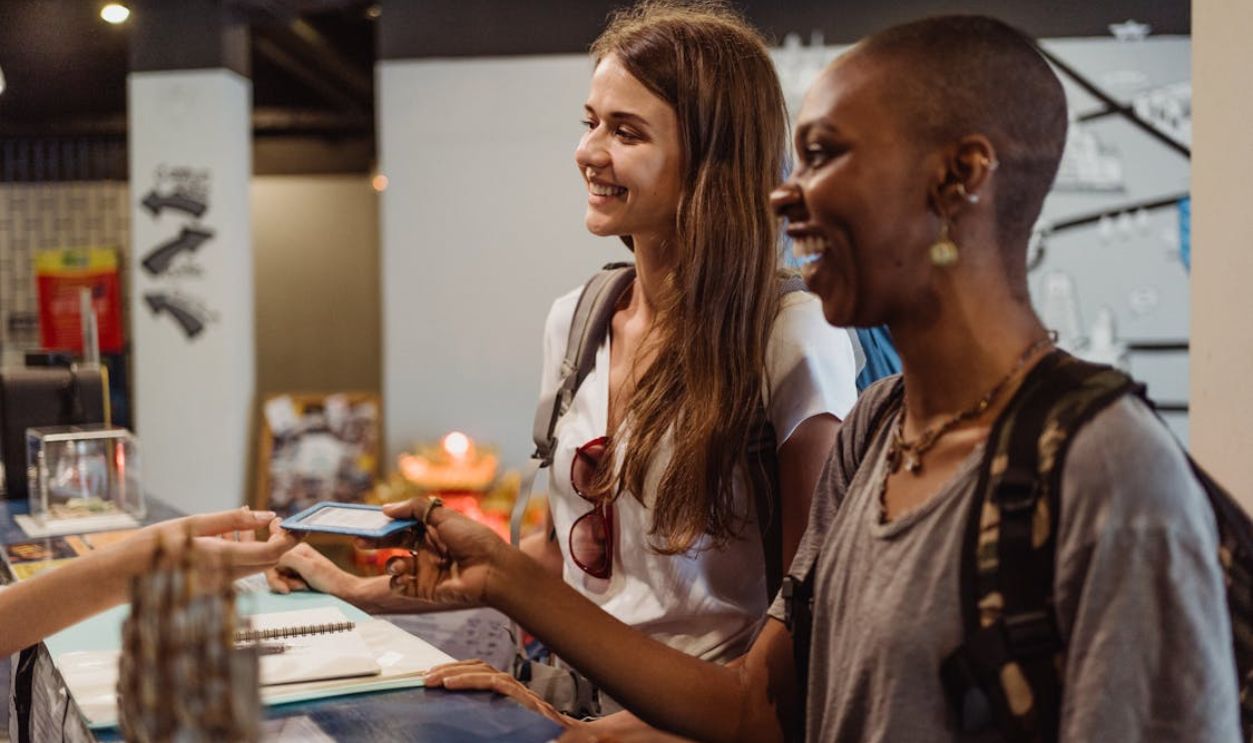 Women Receiving a Hotel Room Card at the Reception Desk 