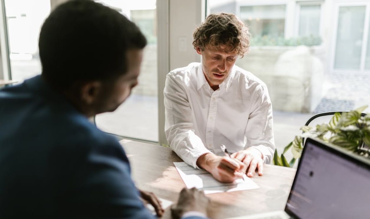 A Man Signing a Document at an Office