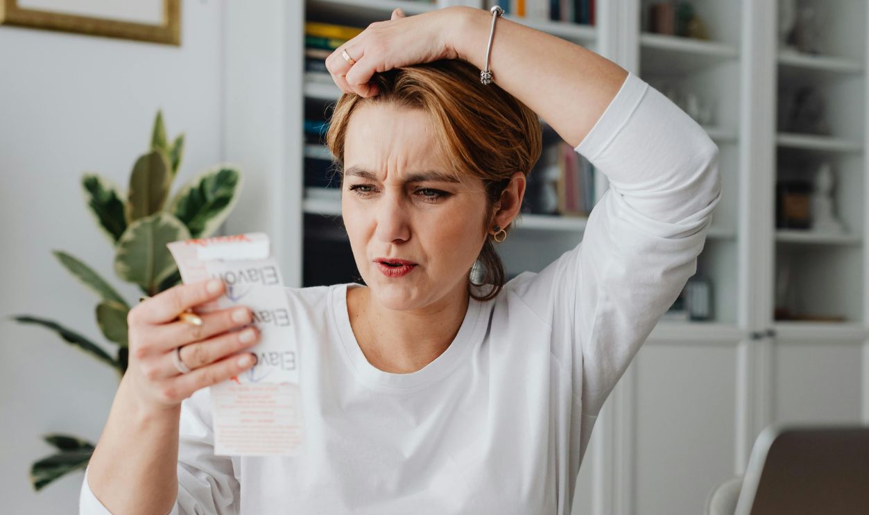 Woman Looking at a Receipt and Making a Surprised Face 