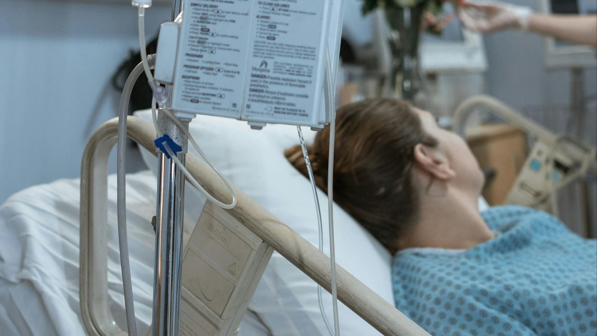 A patient receiving intravenous treatment in a hospital room, emphasizing healthcare and recovery.