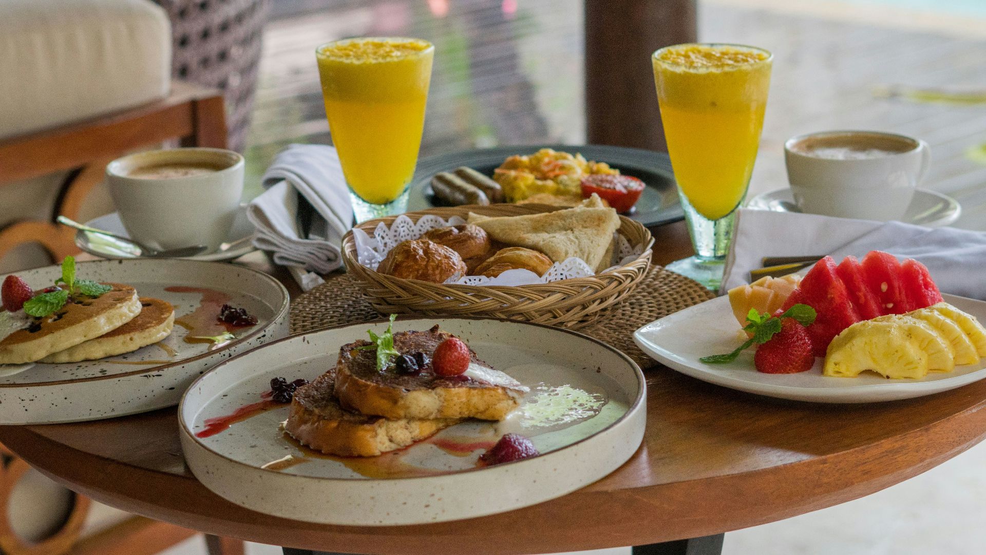 A wooden table topped with plates of food
