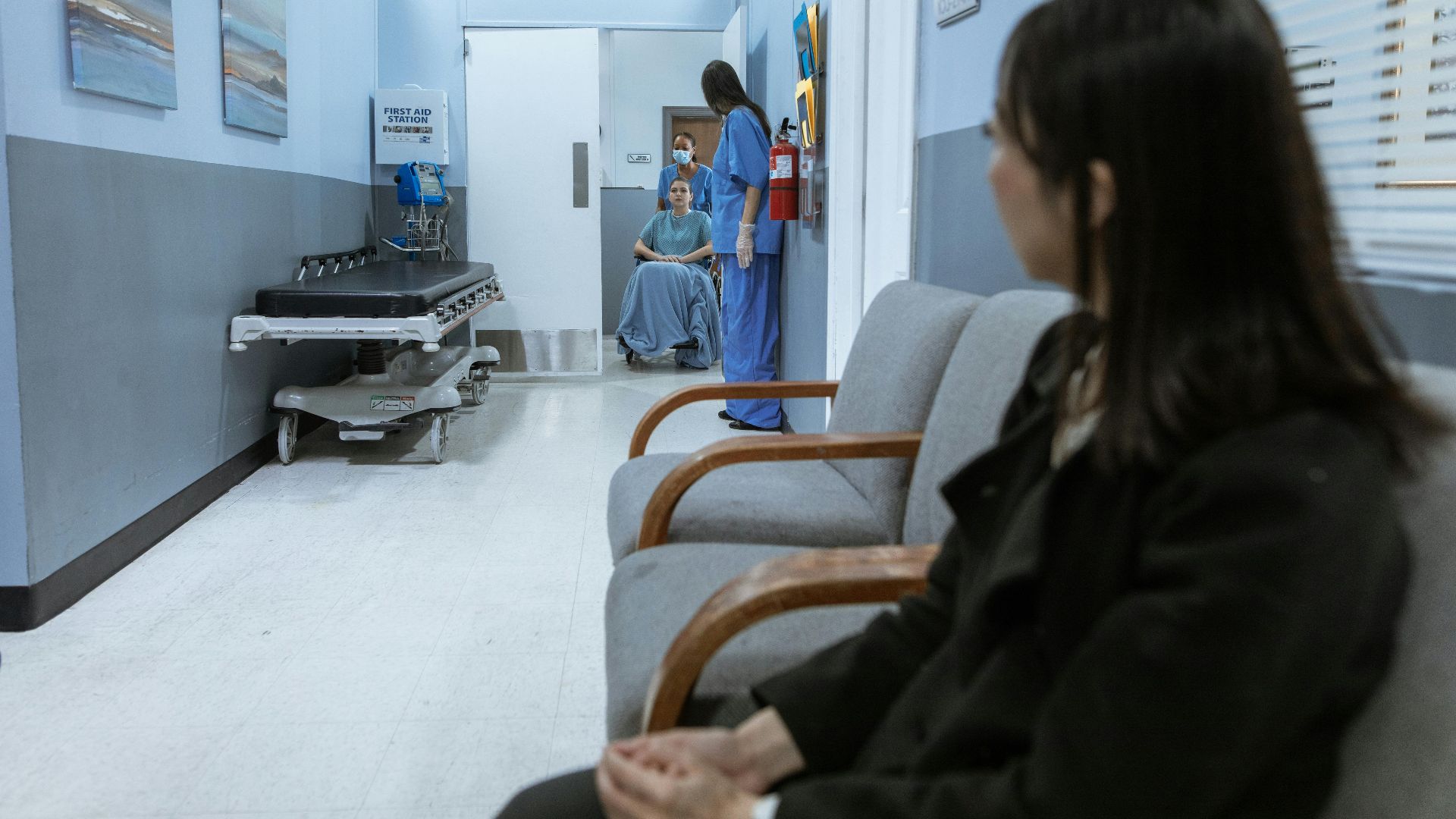 A hospital scene showing patients and medical staff in a corridor, illustrating healthcare environments.