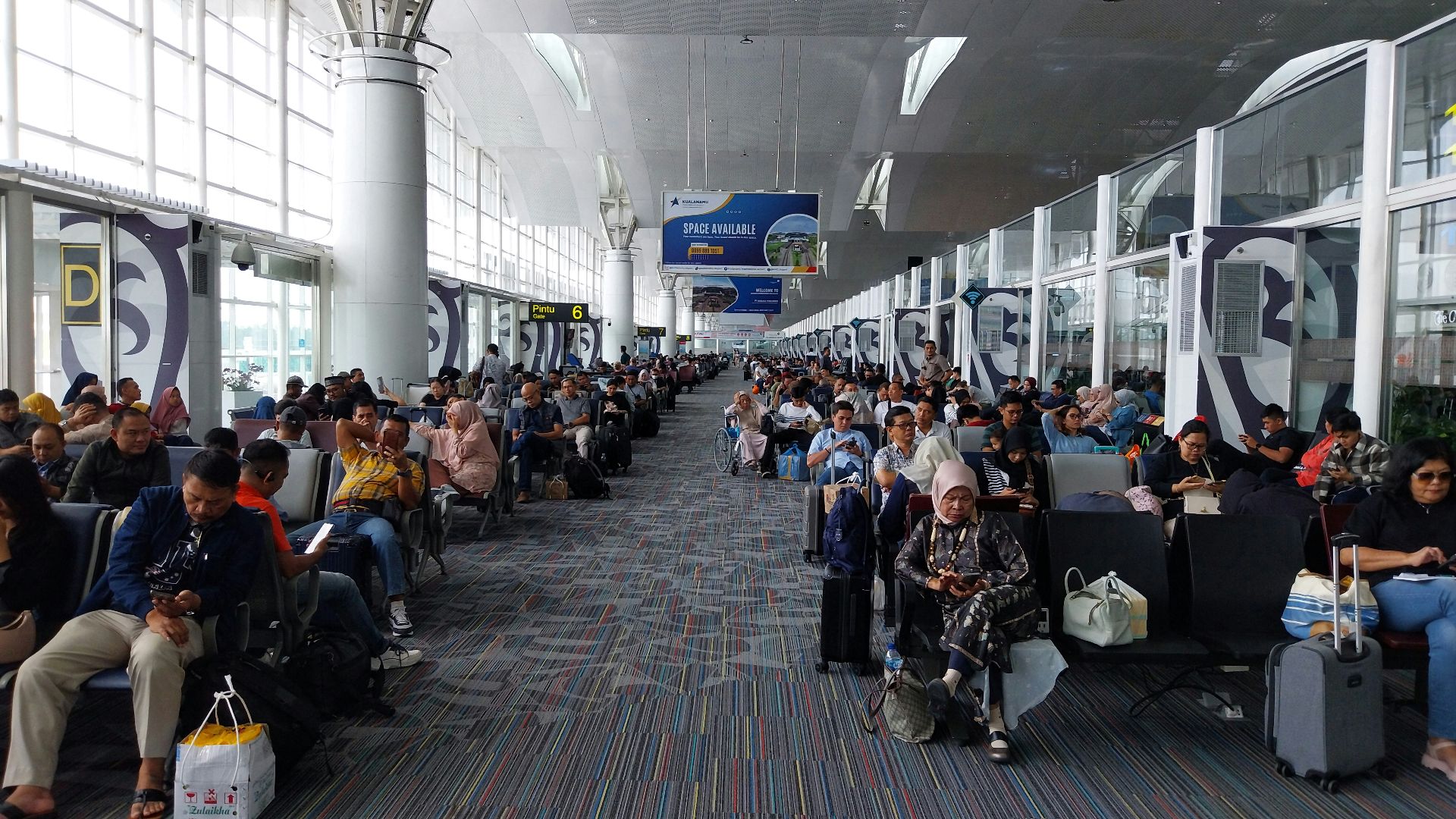 A large group of people waiting for their luggage