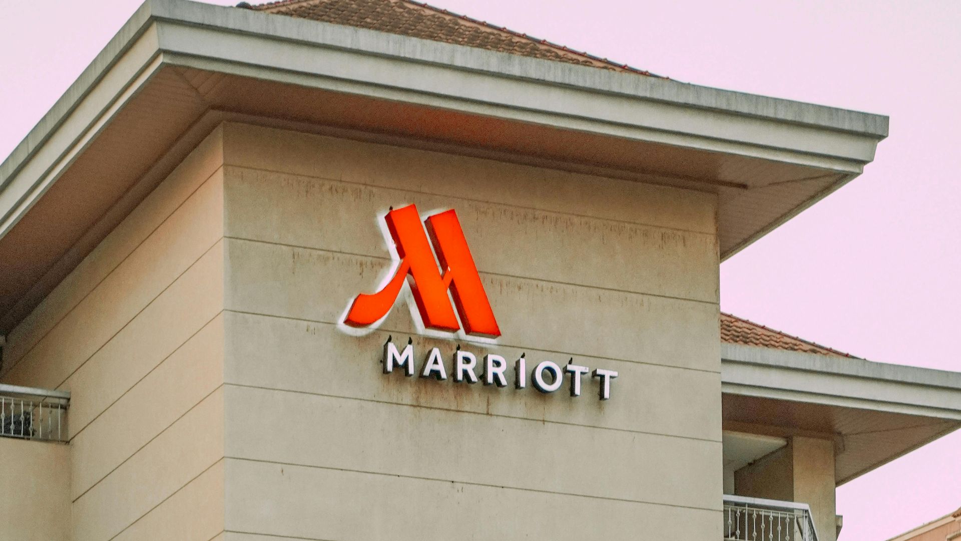 Exterior view of Marriott Hotel building with prominent logo in urban setting.