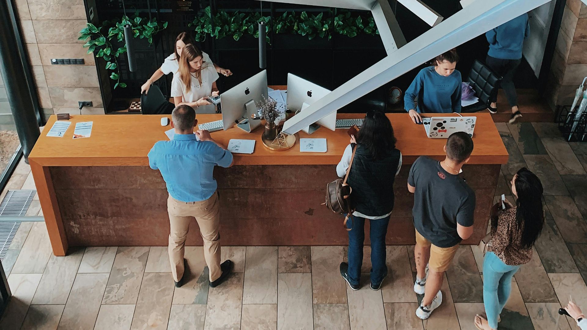 Aerial view of a modern hotel reception with people interacting at the desk in Sosnivka, Ukraine.