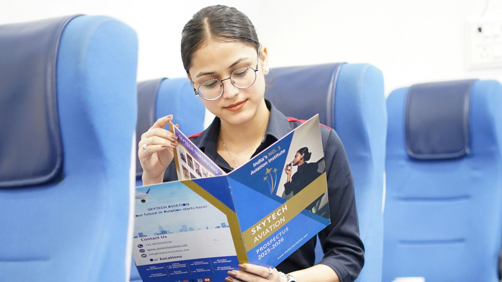 Woman reading brochure while sitting on airplane seat