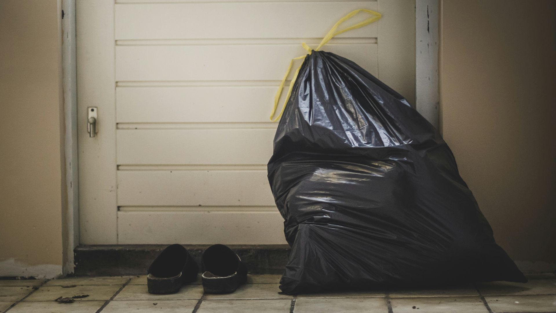 black plastic bag beside white wall