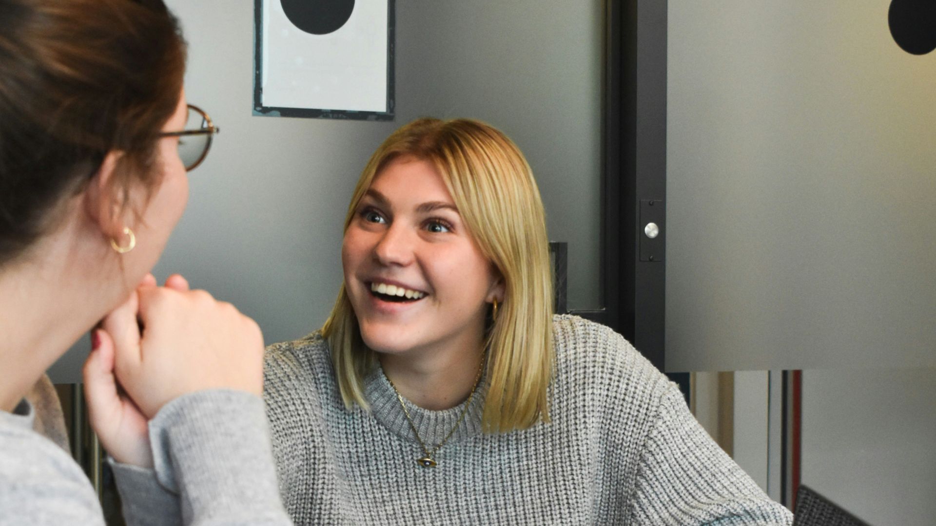 woman in gray sweater sitting beside woman in gray sweater