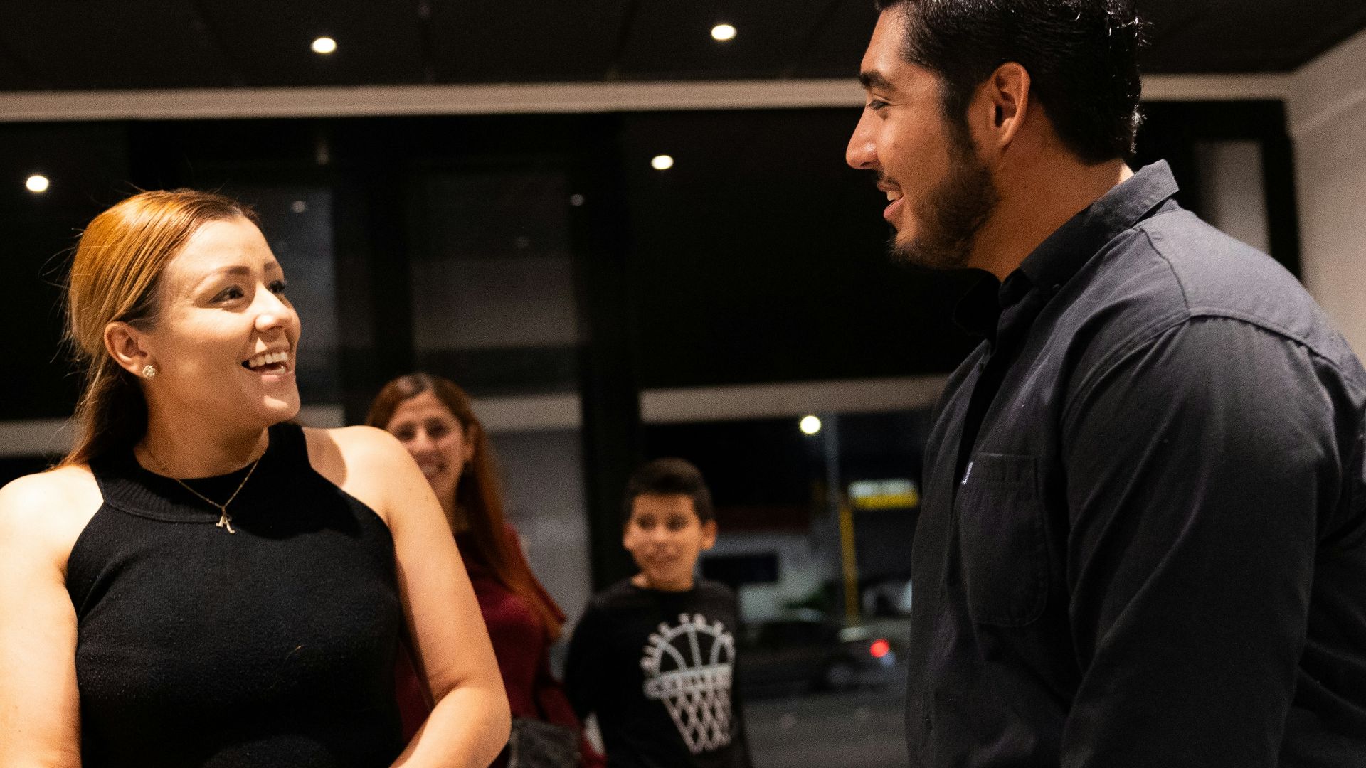 A group of people standing around talking to each other