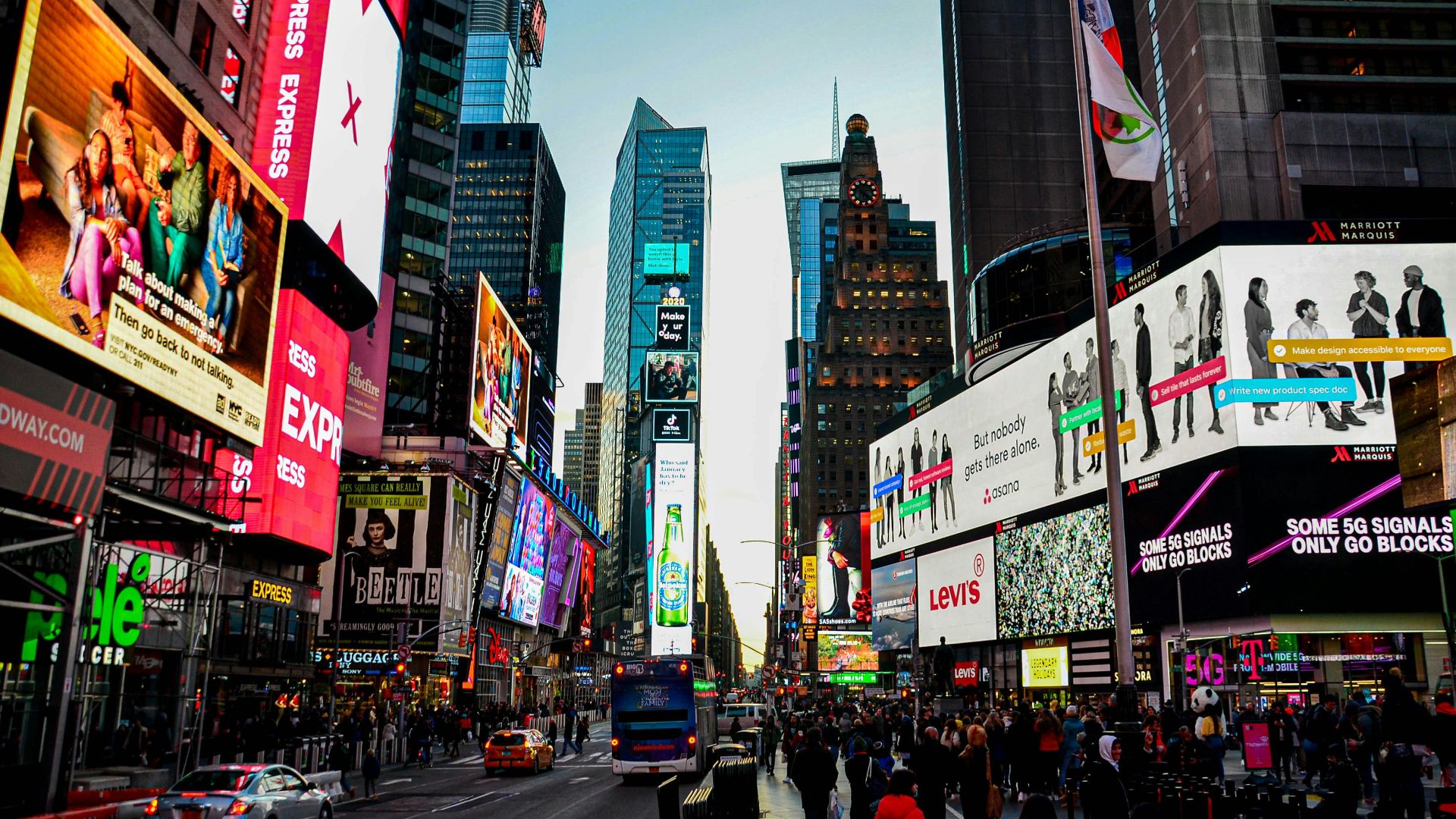 Dynamic cityscape of Times Square, New York, bustling with lights and activity at dusk.