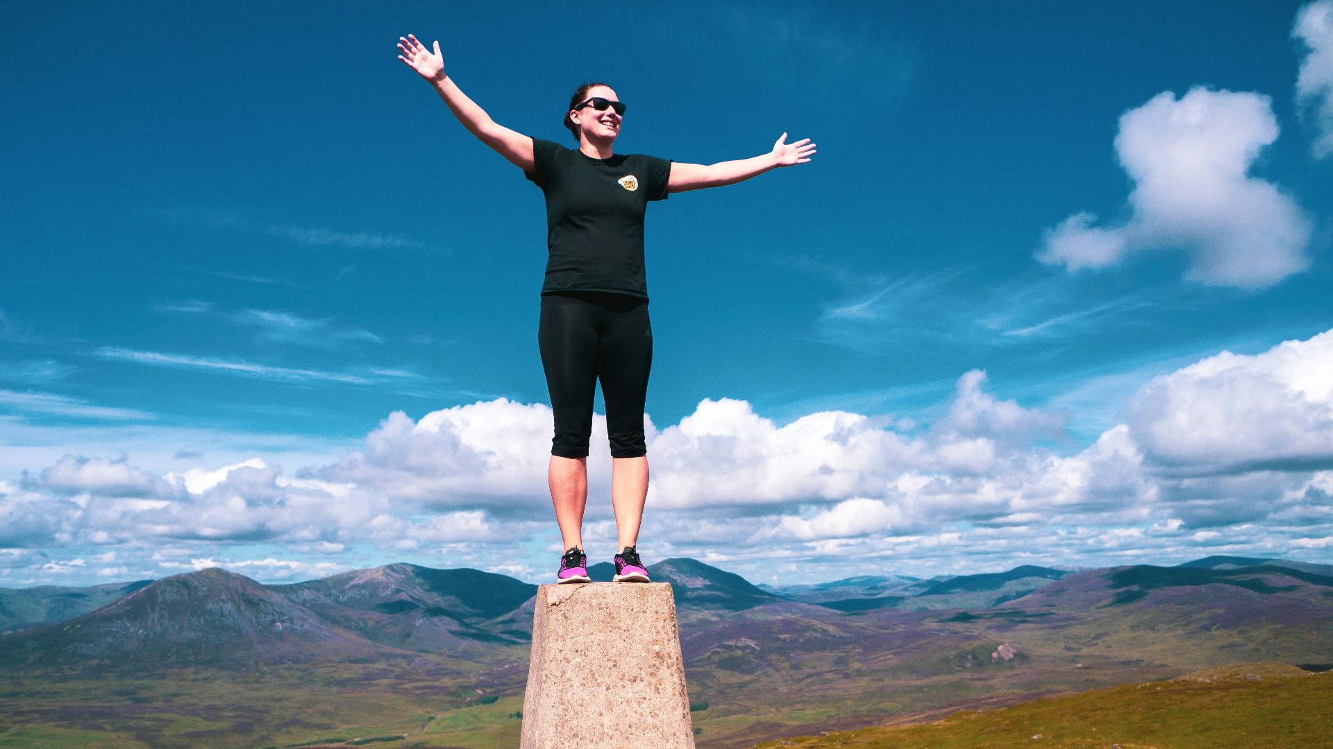 a woman standing on top of a stone pillar