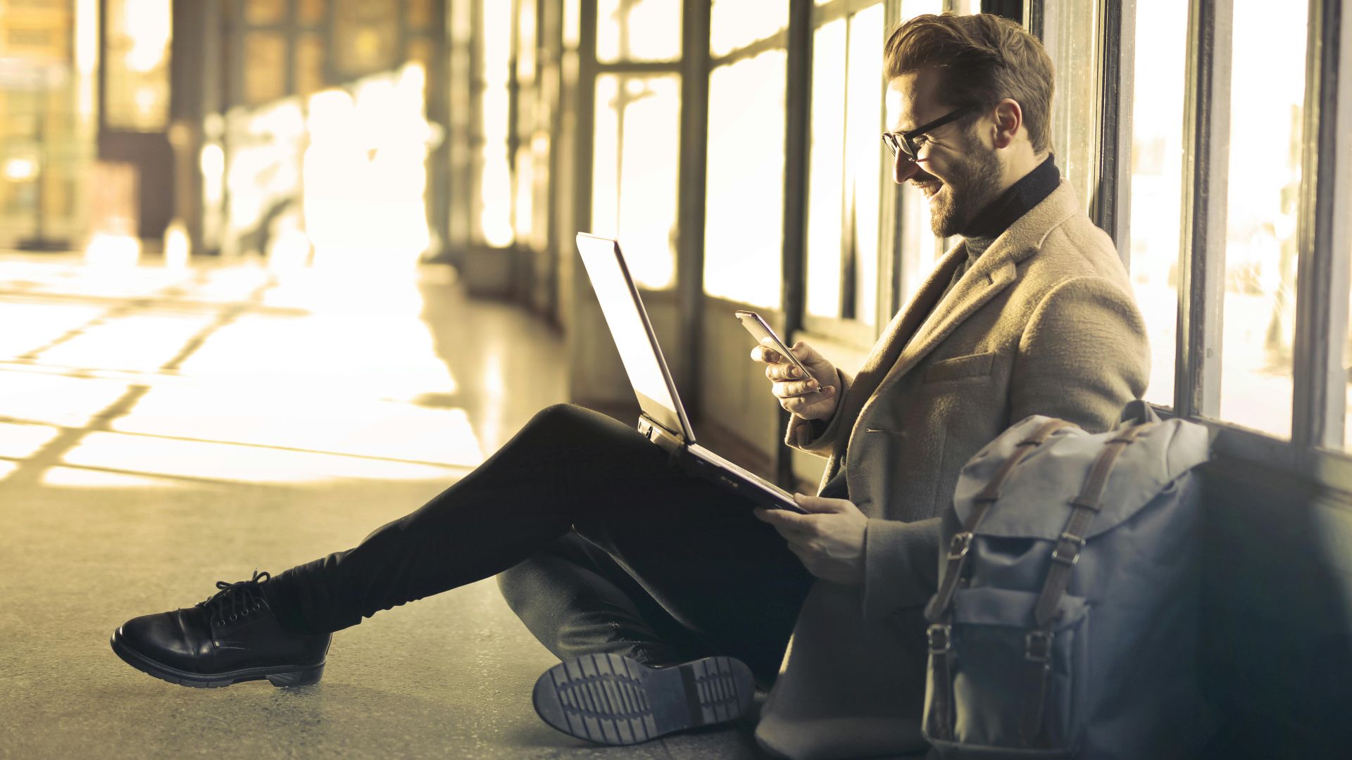 Man sitting with a laptop and smartphone, representing digital nomad lifestyle and remote work.