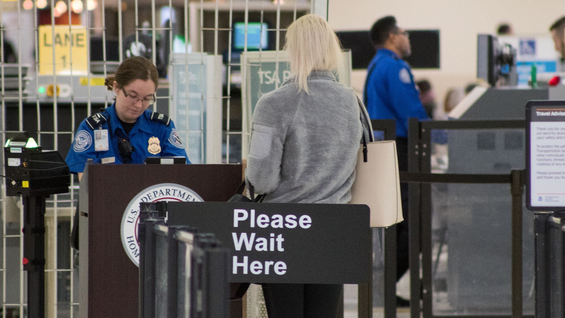 A Transportation Security Administration agent at a checkpoint verifying passenger identification, John Glenn Columbus International Airport