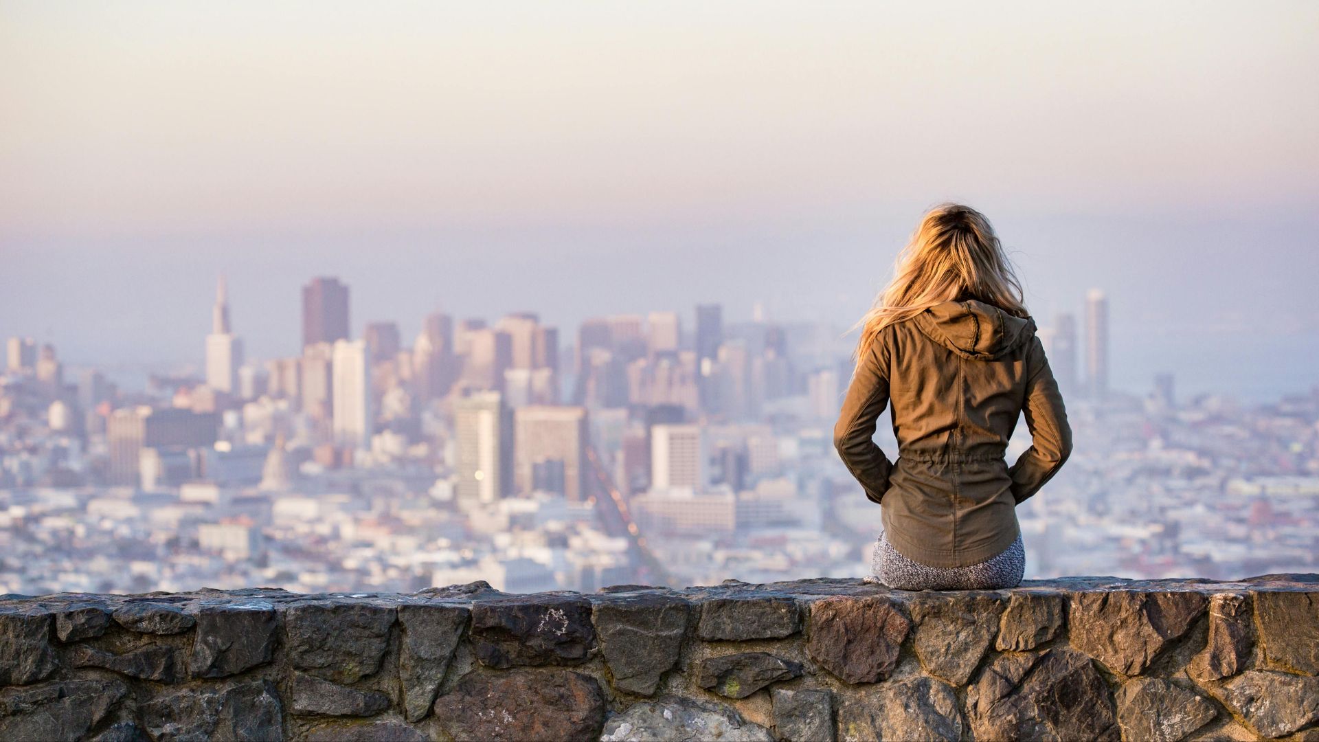 A woman overlooks the stunning skyline of San Francisco at daylight, capturing the city's urban beauty.