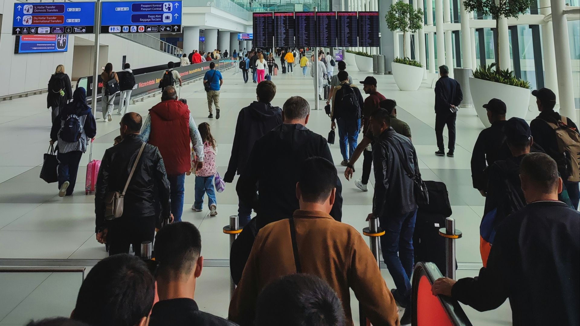 People walk through a modern, spacious airport terminal.