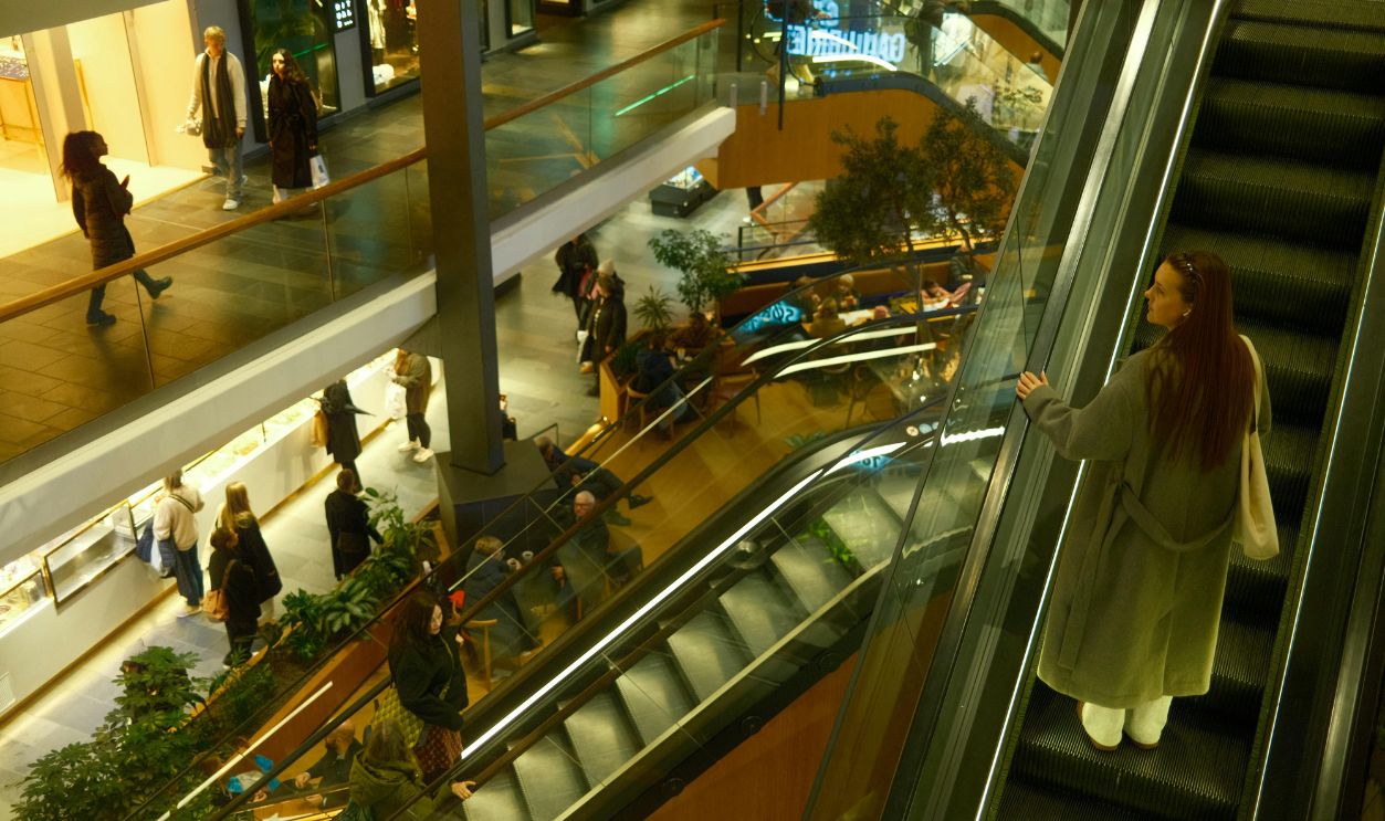 Modern Shopping Mall with Escalator and Shoppers