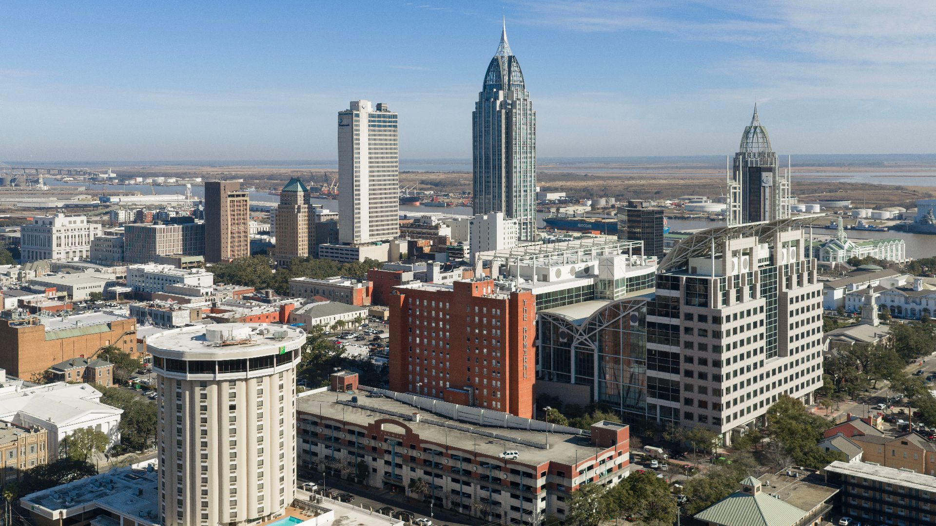 Skyline of Mobile, Alabama, viewed from the west, with downtown buildings along the Mobile River.
