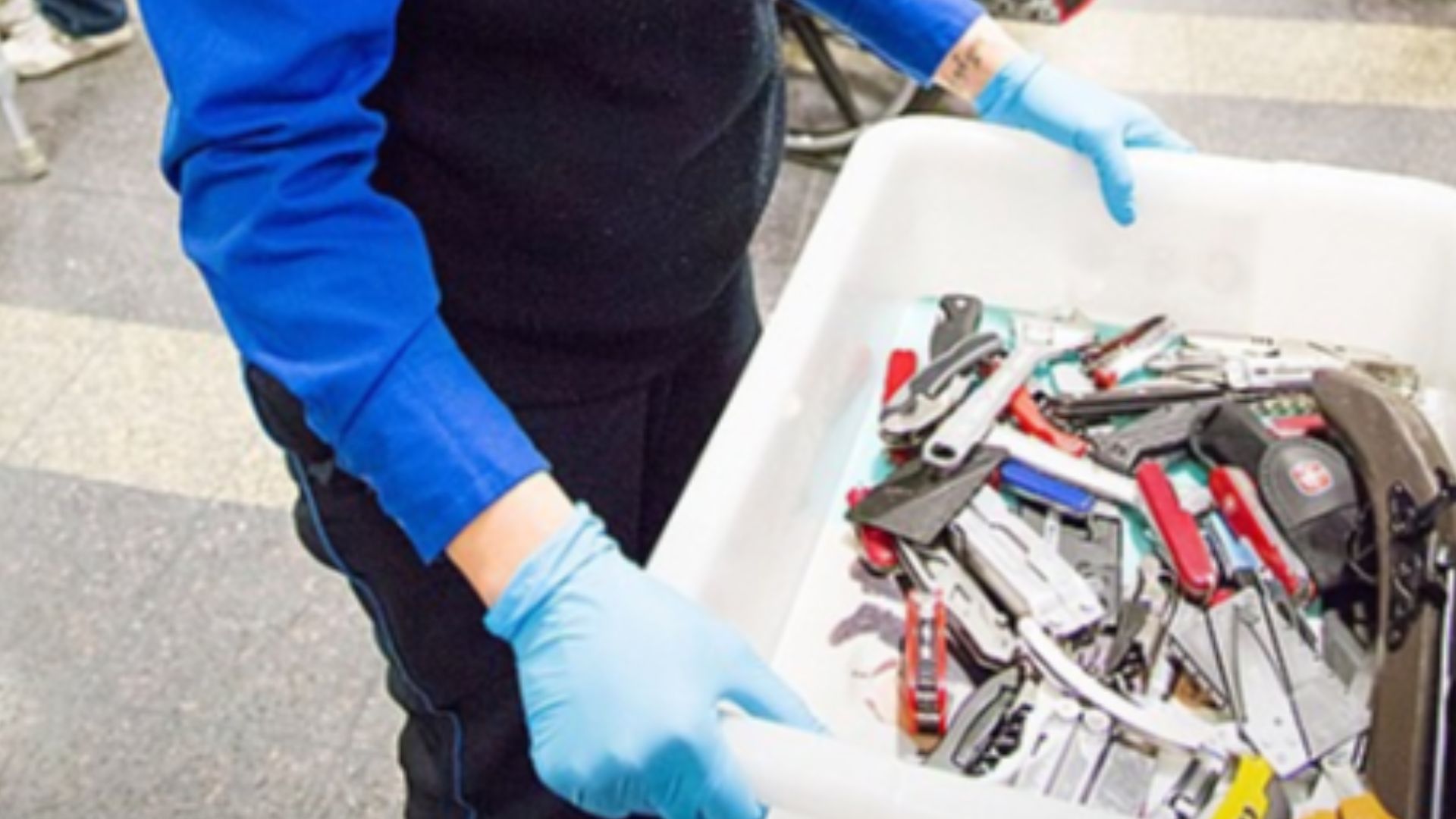 TSA officer carrying prohibited items (on board of aircraft) in a bin