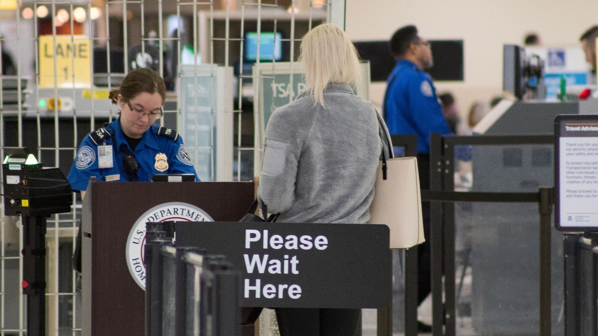 A Transportation Security Administration agent at a checkpoint verifying passenger identification, John Glenn Columbus International Airport