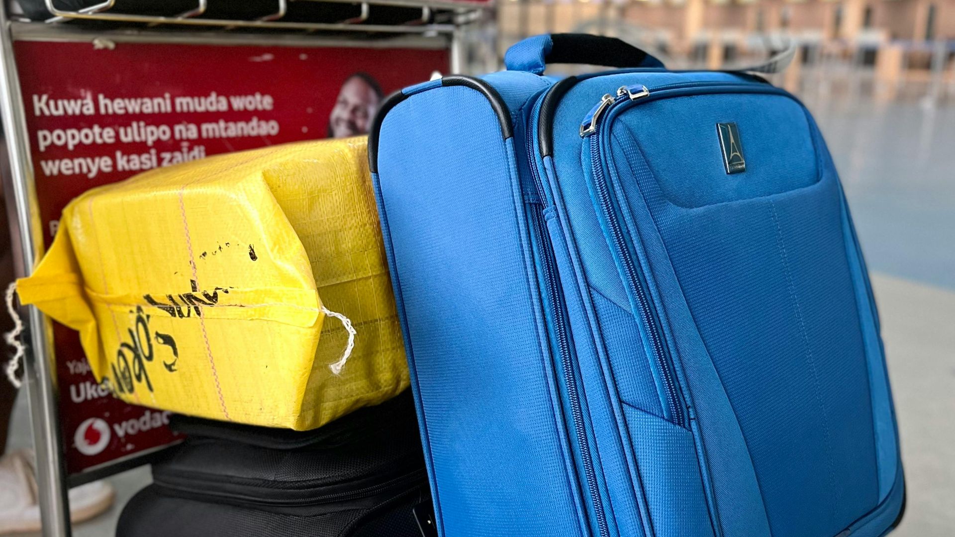 Luggage on trolley in Dar es Salaam Airport, Tanzania, showcasing travel preparation and mobility.