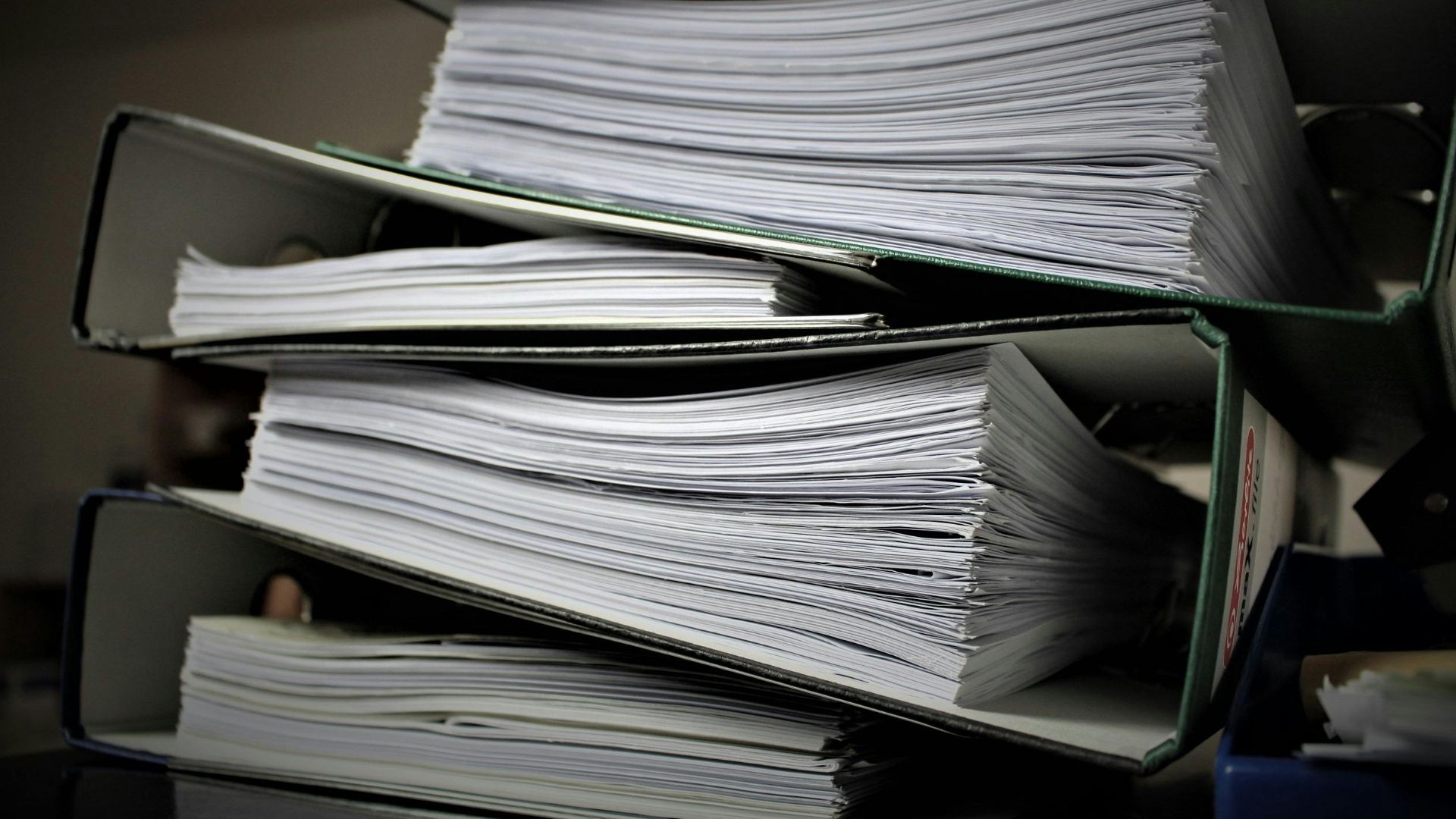 Close-up of stacked binders filled with documents for office or educational use.