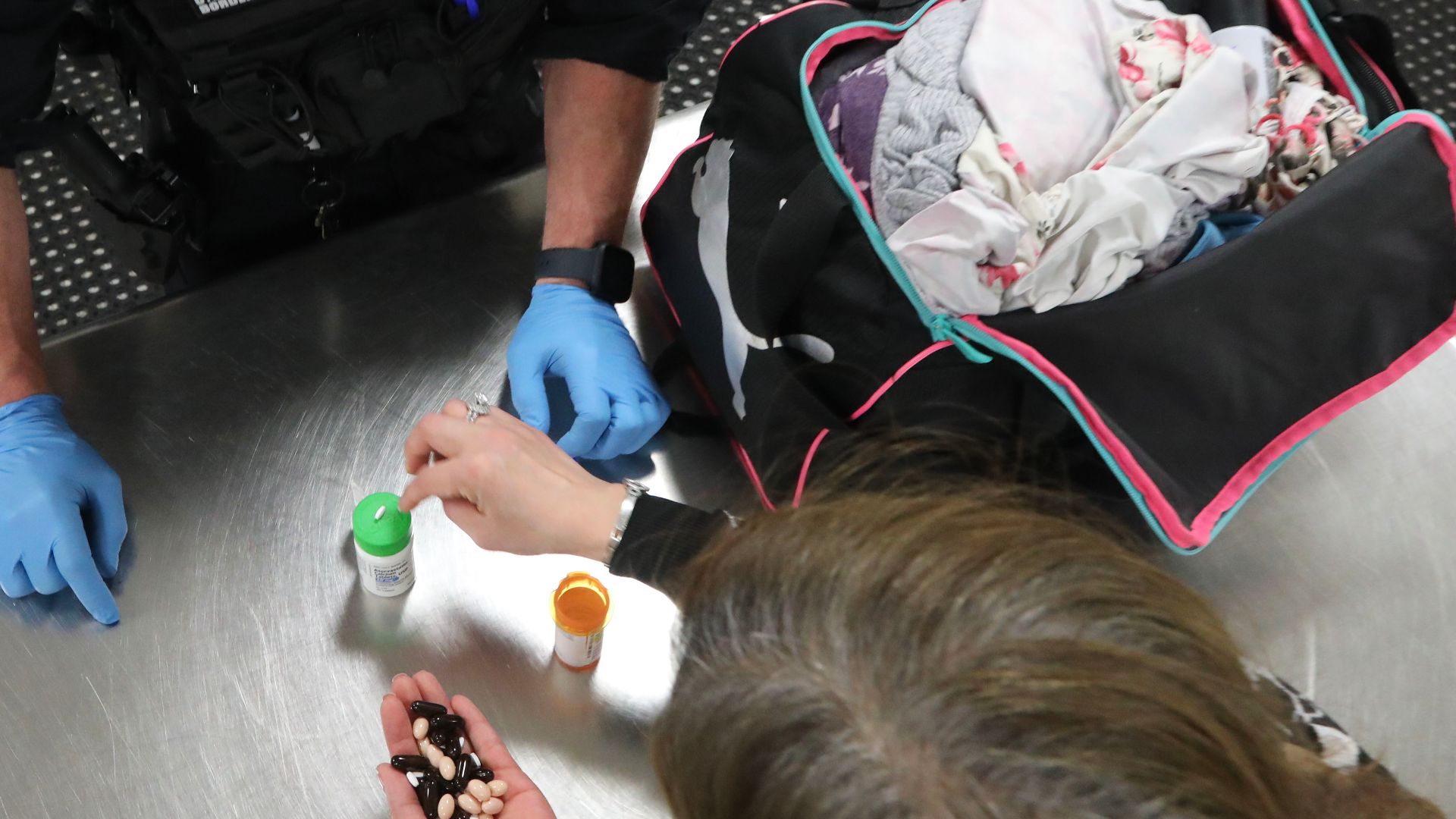 A U.S. Customs and Border Protection officer inspects medicine found in a passenger’s bag who had been referred for secondary examination, April 29, 2024, Dulles Airport, Sterling, Va.