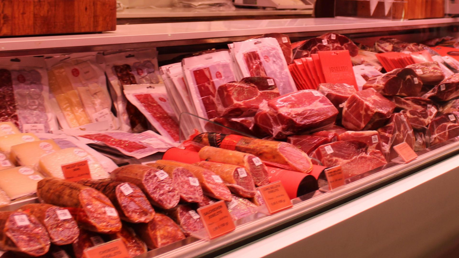 Fresh meat selection in a Barcelona market deli, vibrant display and diverse cuts.