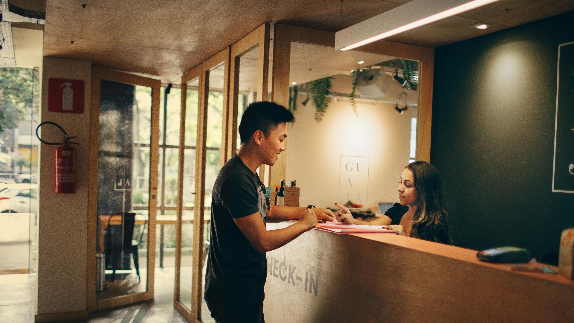 A customer checks in at a hotel reception desk in Belo Horizonte, Brazil.