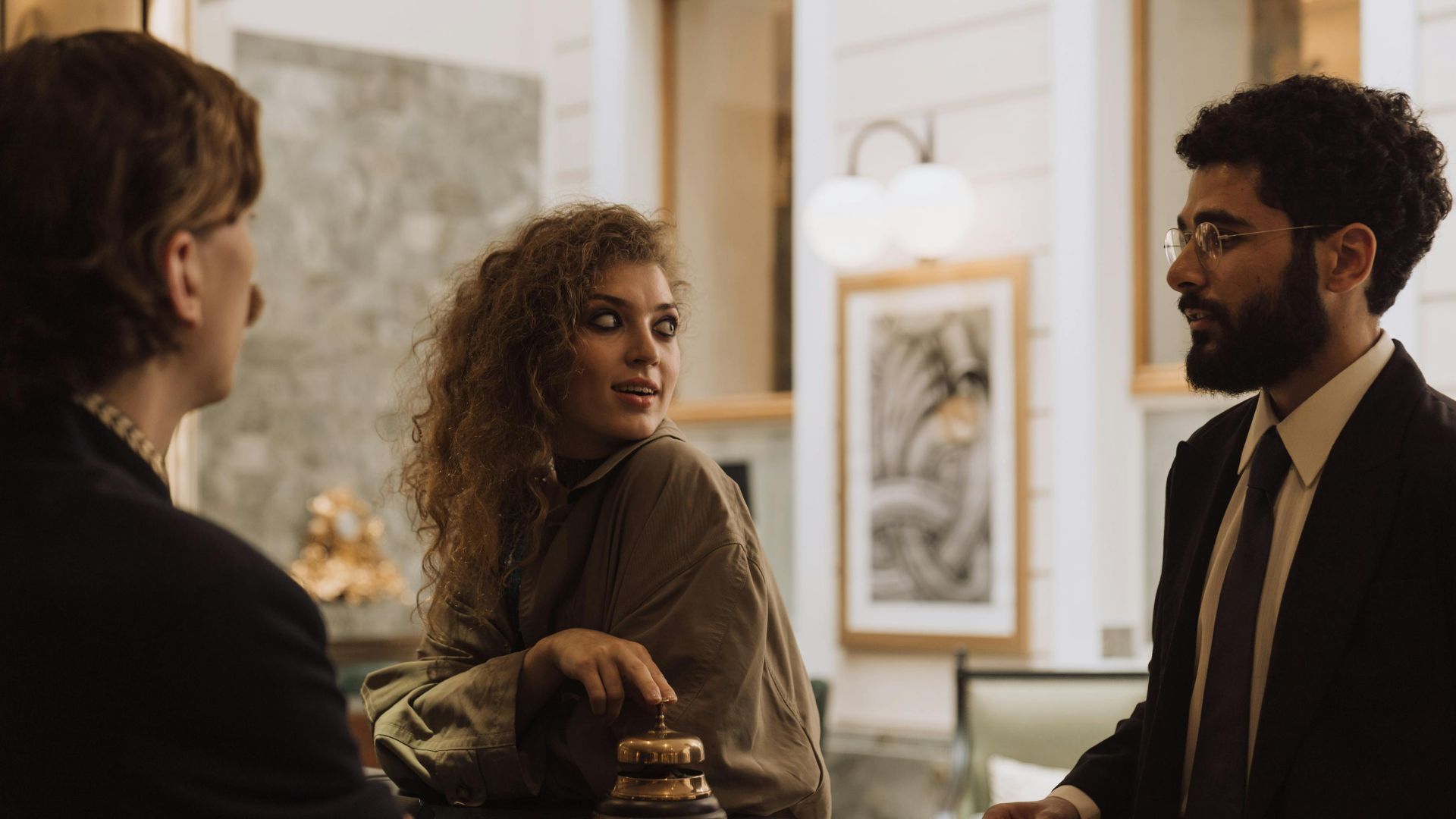 Guests interacting at a luxurious hotel reception desk, emphasizing hospitality and service.