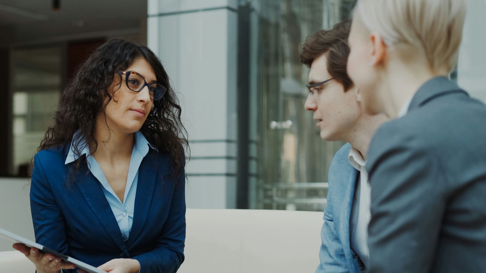 Three professionals in a business meeting discussion