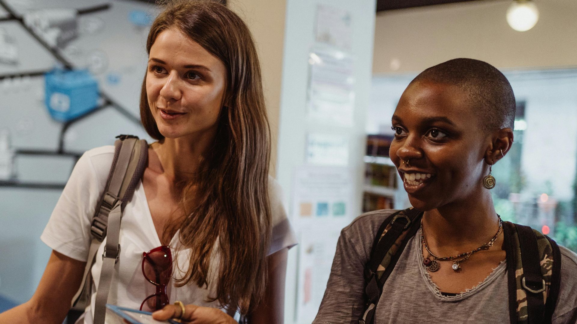 Two women tourists engaging at a hostel reception, offering a friendly atmosphere.