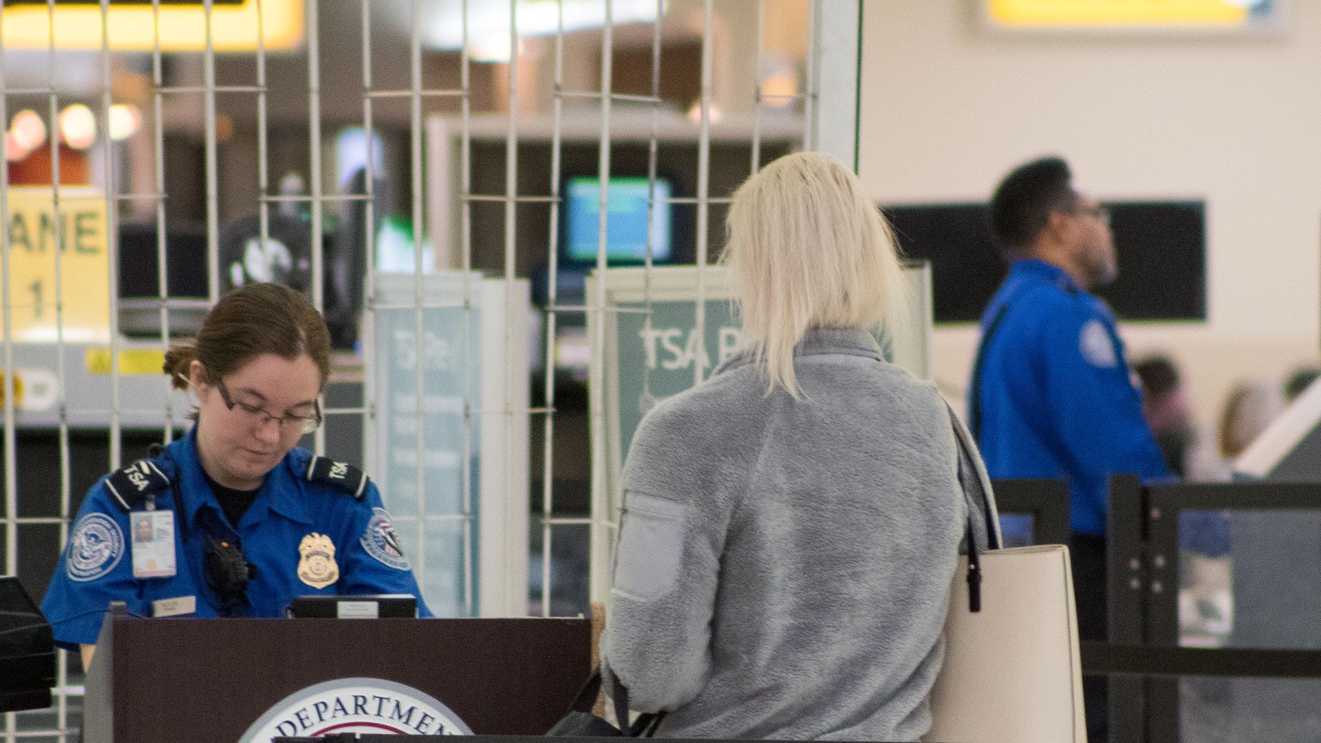 A Transportation Security Administration agent at a checkpoint verifying passenger identification, John Glenn Columbus International Airport