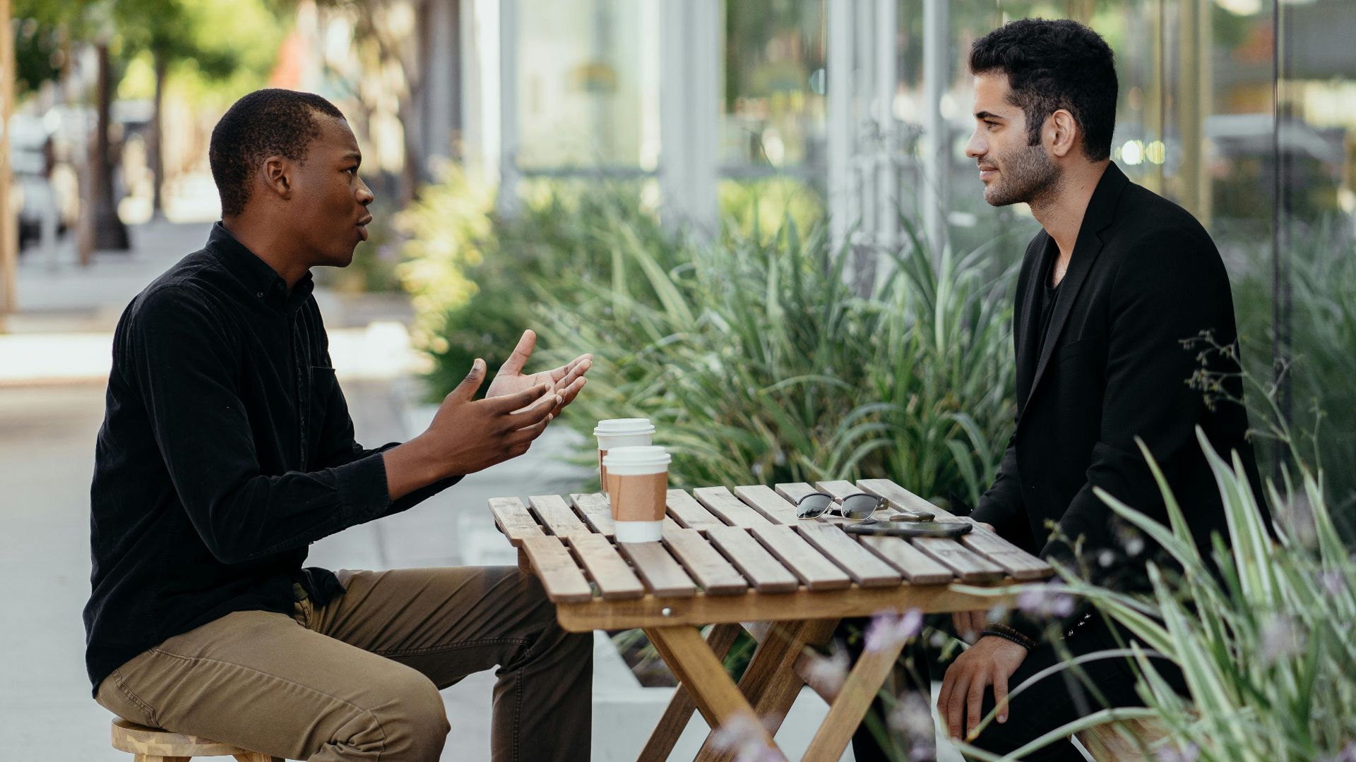 Two men having a business meeting at an outdoor café setting.