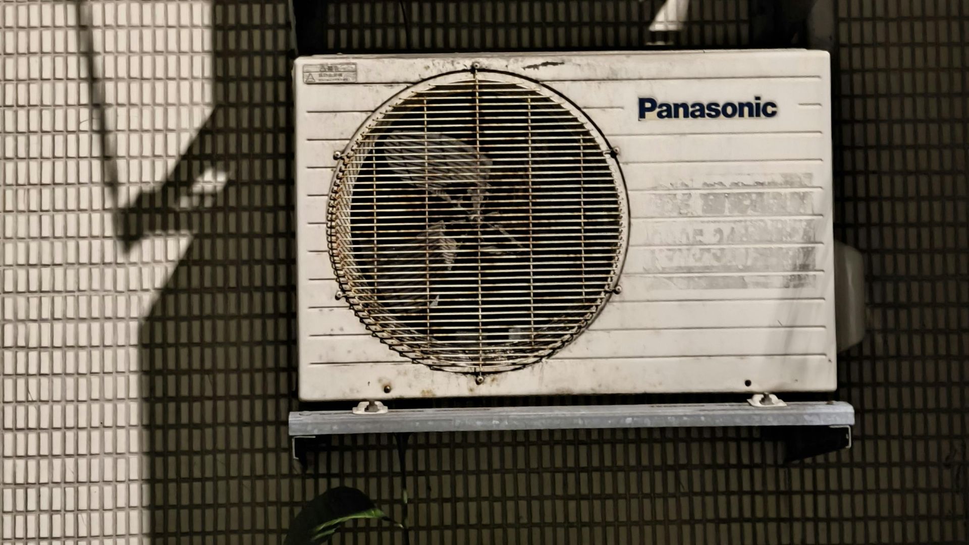 Close-up of two air conditioning units on a building facade in sunlight.