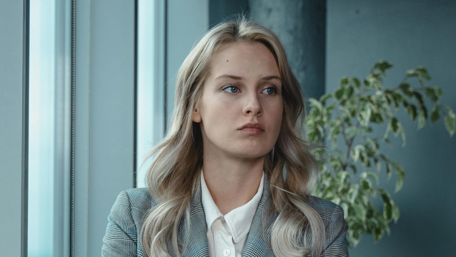 A professional businesswoman stands confidently in a modern office, exuding leadership and determination.