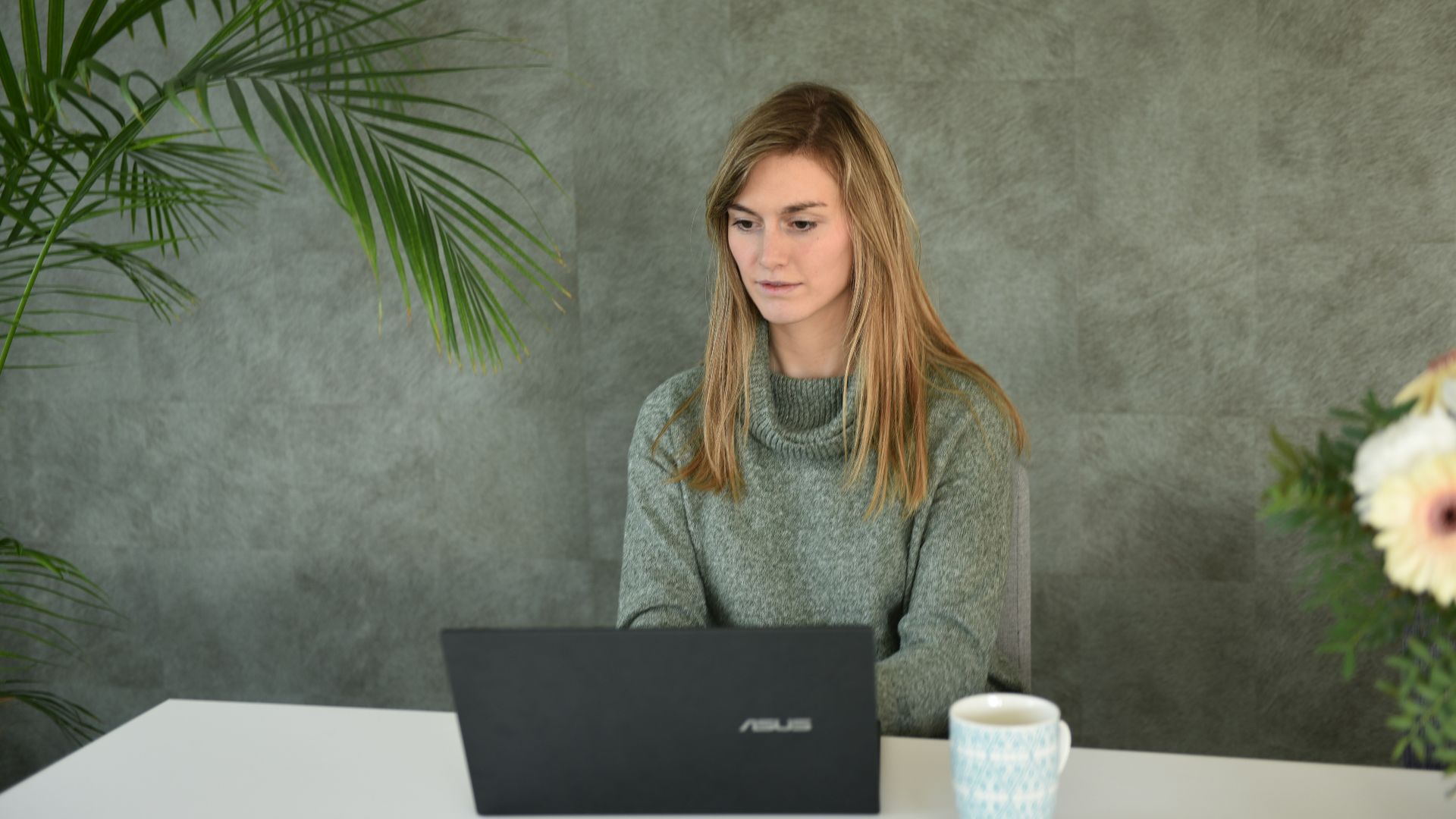 a woman sitting at a table with a laptop