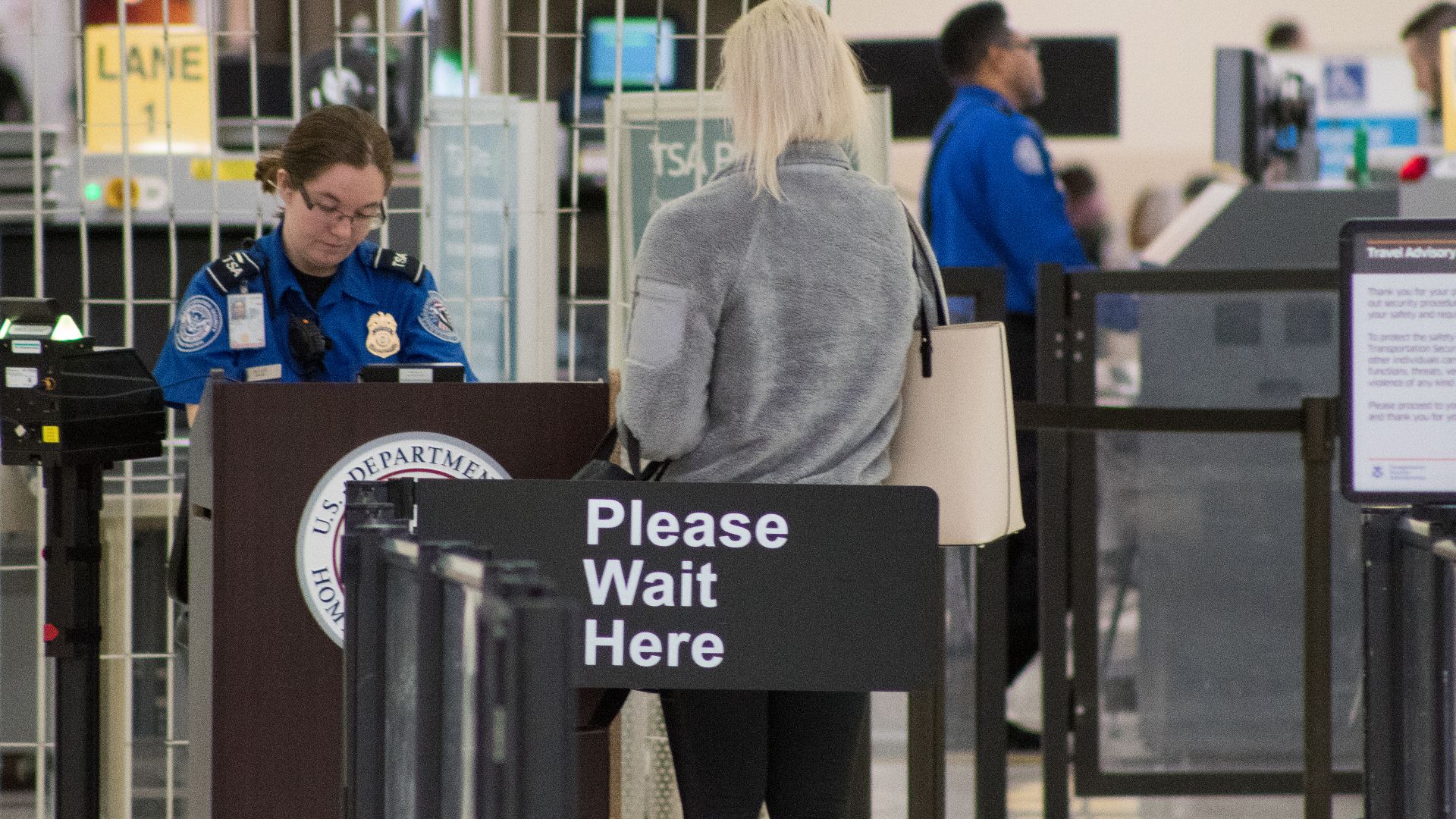 A Transportation Security Administration agent at a checkpoint verifying passenger identification, John Glenn Columbus International Airport
