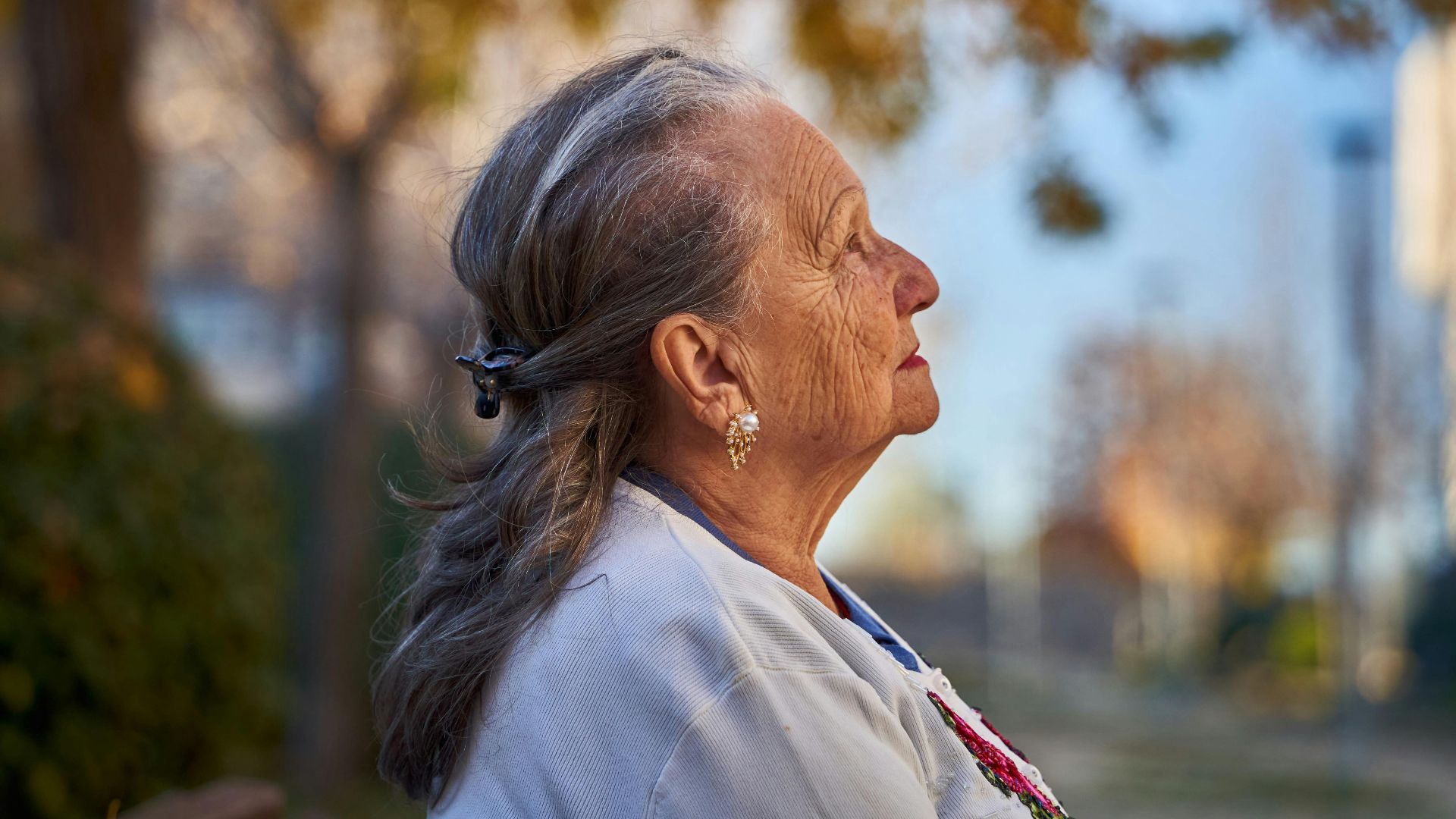 Side profile portrait of a senior woman in a sunny autumn park, San Sebastián de los Reyes.
