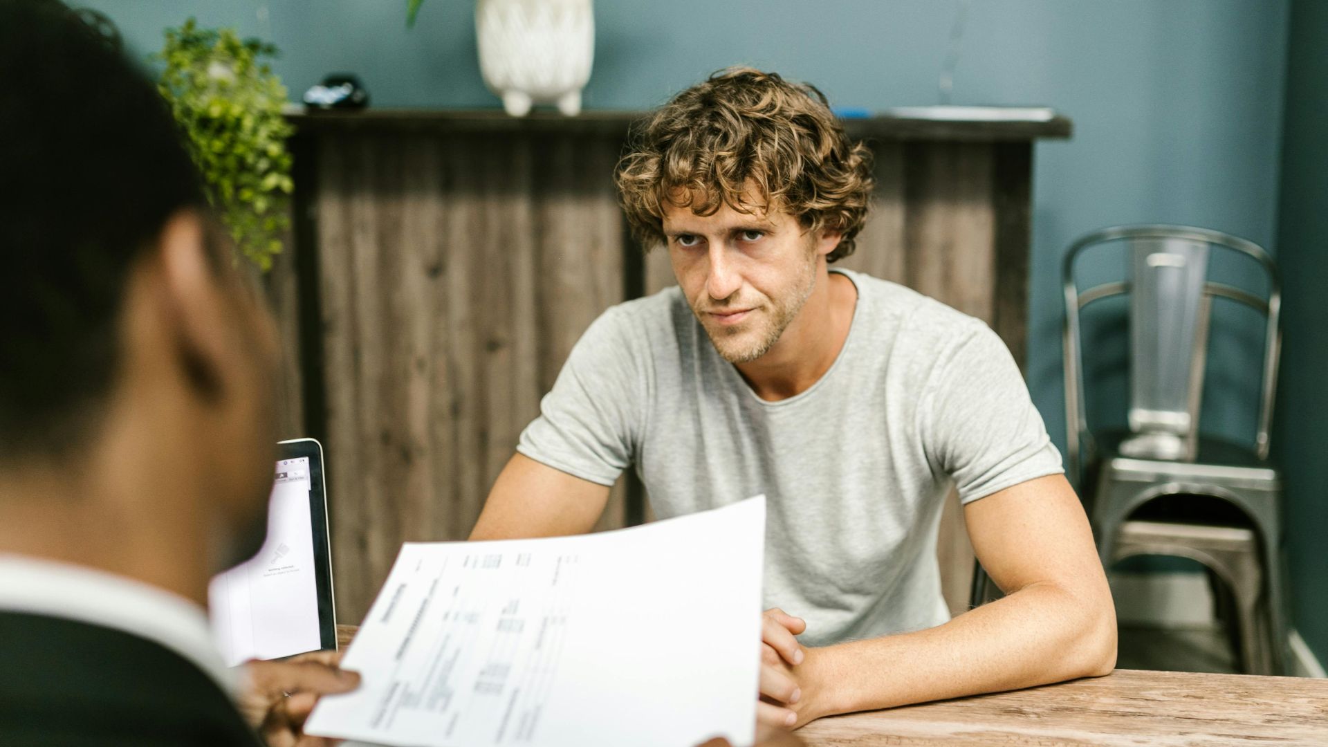 Two men in discussion over documents during a business meeting in a contemporary office setting.
