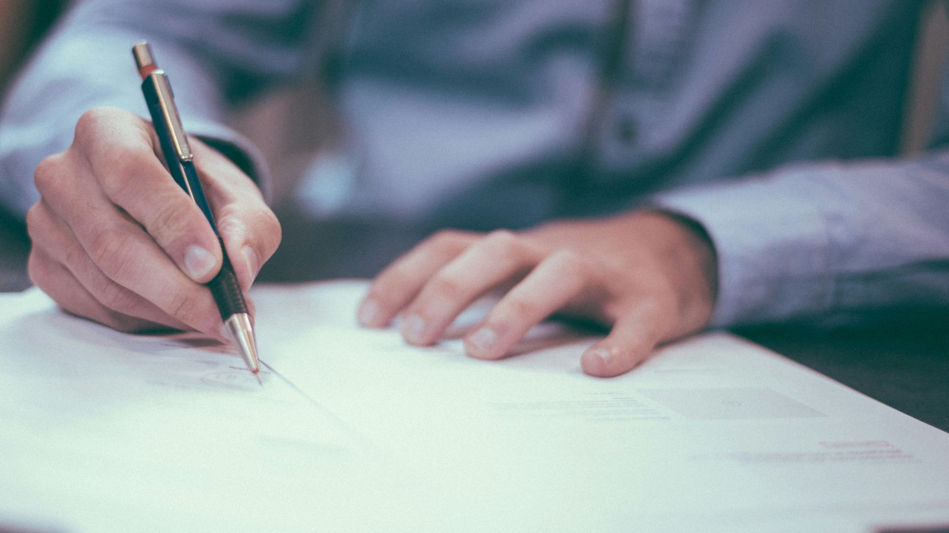 man writing on paper