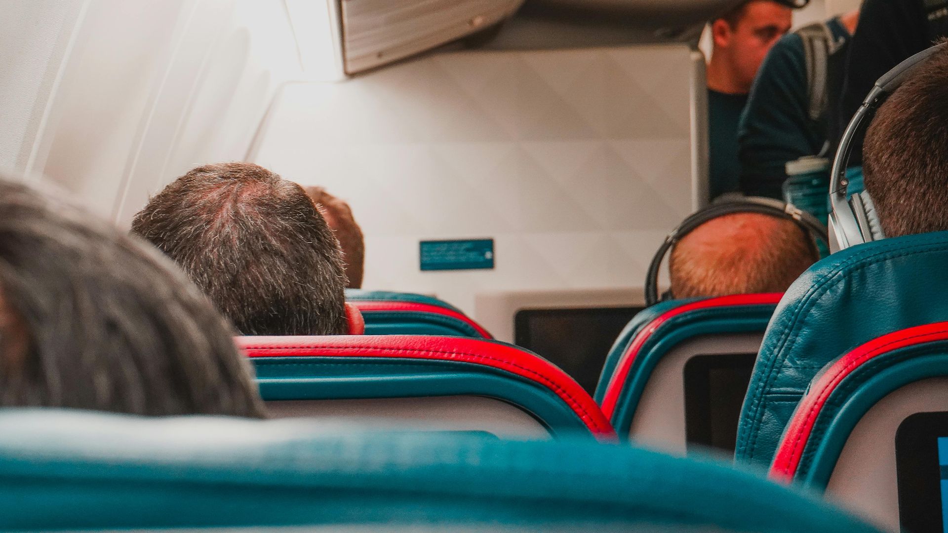 Interior view of an airplane cabin with passengers seated, focusing on seats and layout.