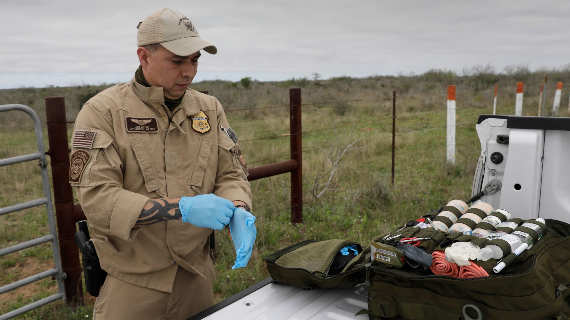U.S. Customs and Border Protection Air and Marine Operations Special Air Crewman Jose Palomo dons gloves prior to administering aid to a sick illegal border crosser captured by U.S. Border Patrol agents near Hebbronville, Texas, March 7, 2019. U.S. Customs and Border Protection Photo by Glenn Fawcett