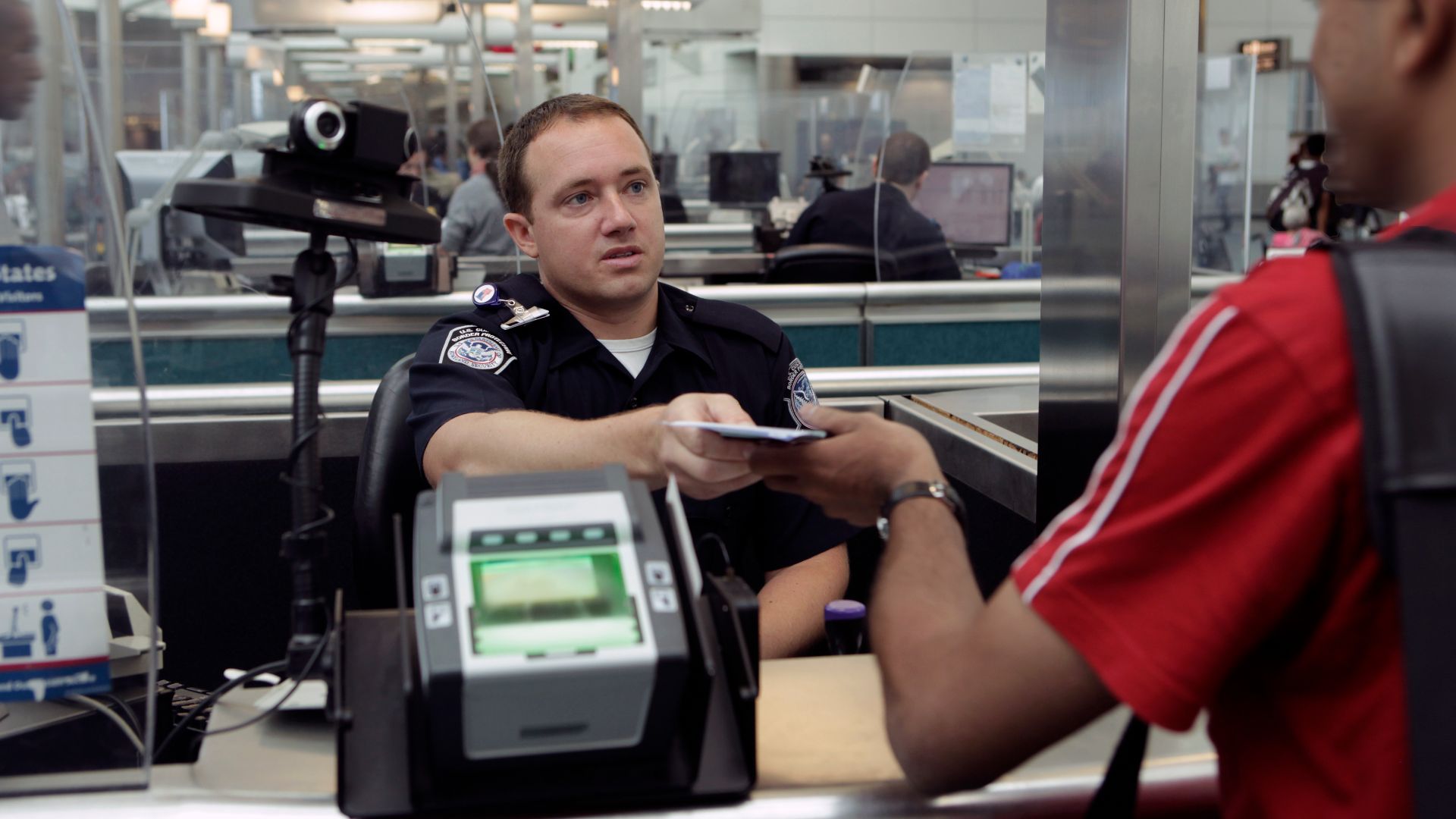A CBP Officer processes an incoming passenger at the Newark International Airport.  Photo by James Tourtellotte