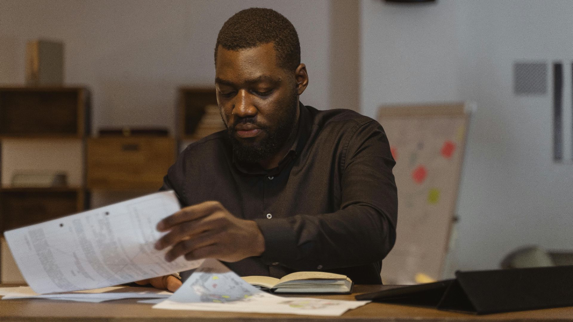 A serious businessman reviews important papers in a modern office setting.