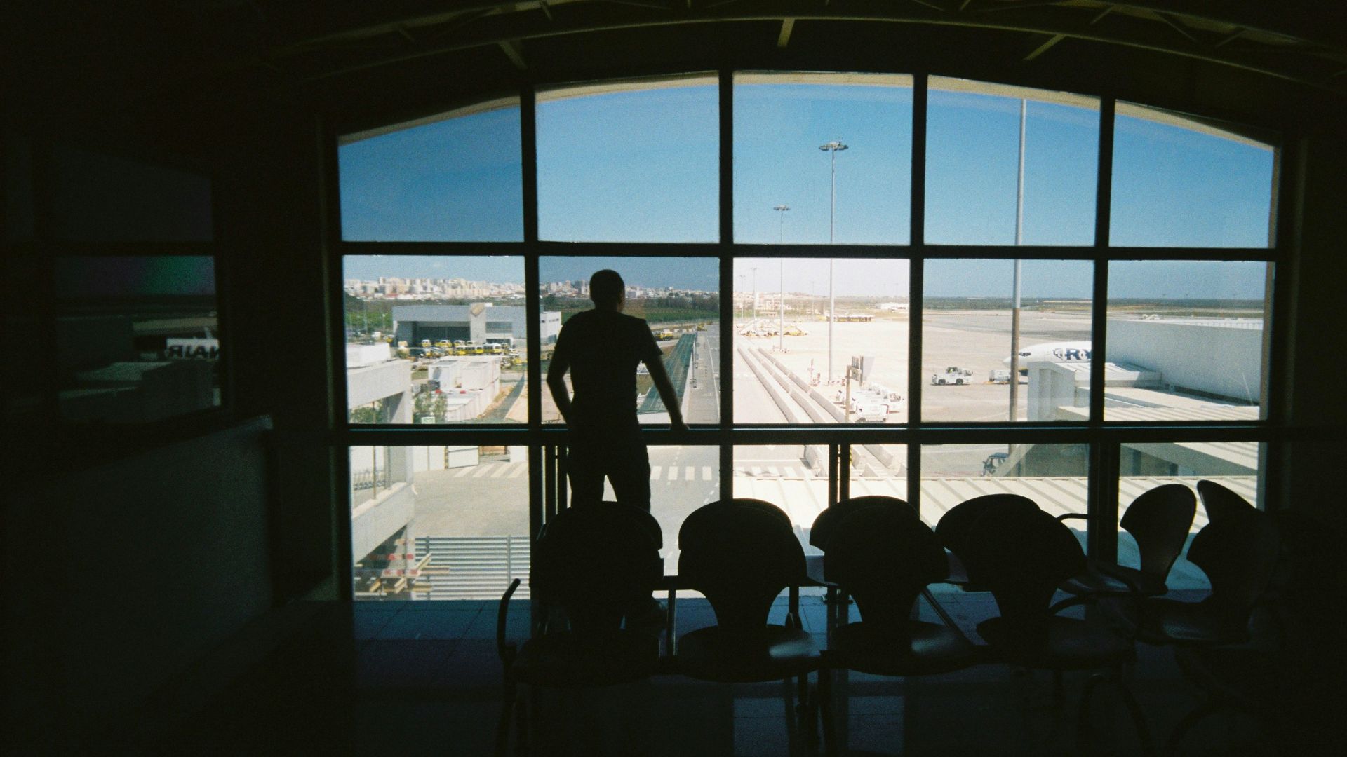 silhouette of man standing near glass window